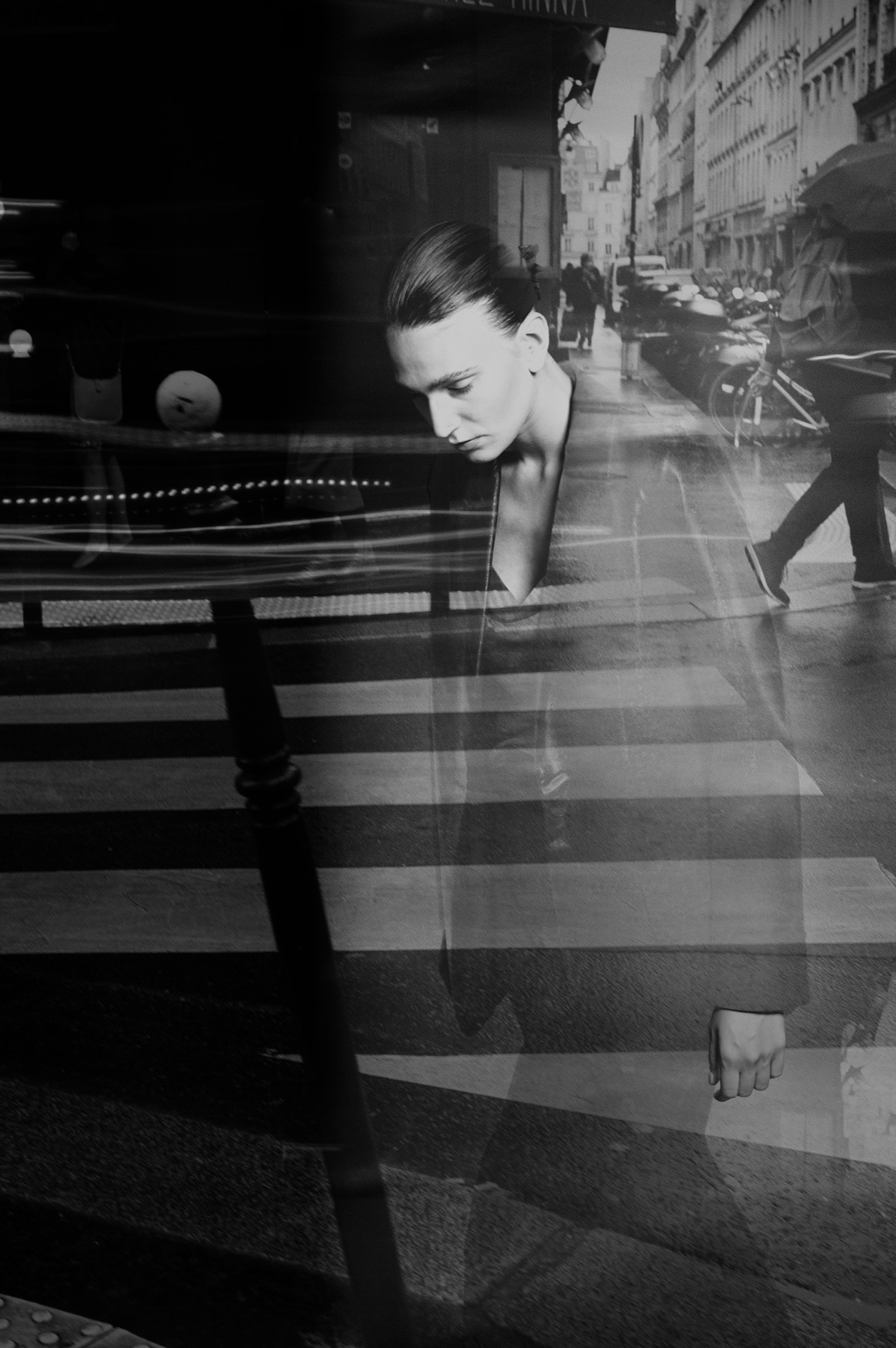 Cinematic black-and-white portrait reflected in a Paris café window
