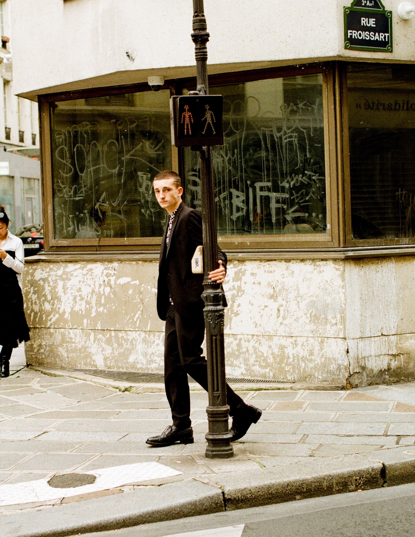 Analog-style portrait beside a Paris street lamp