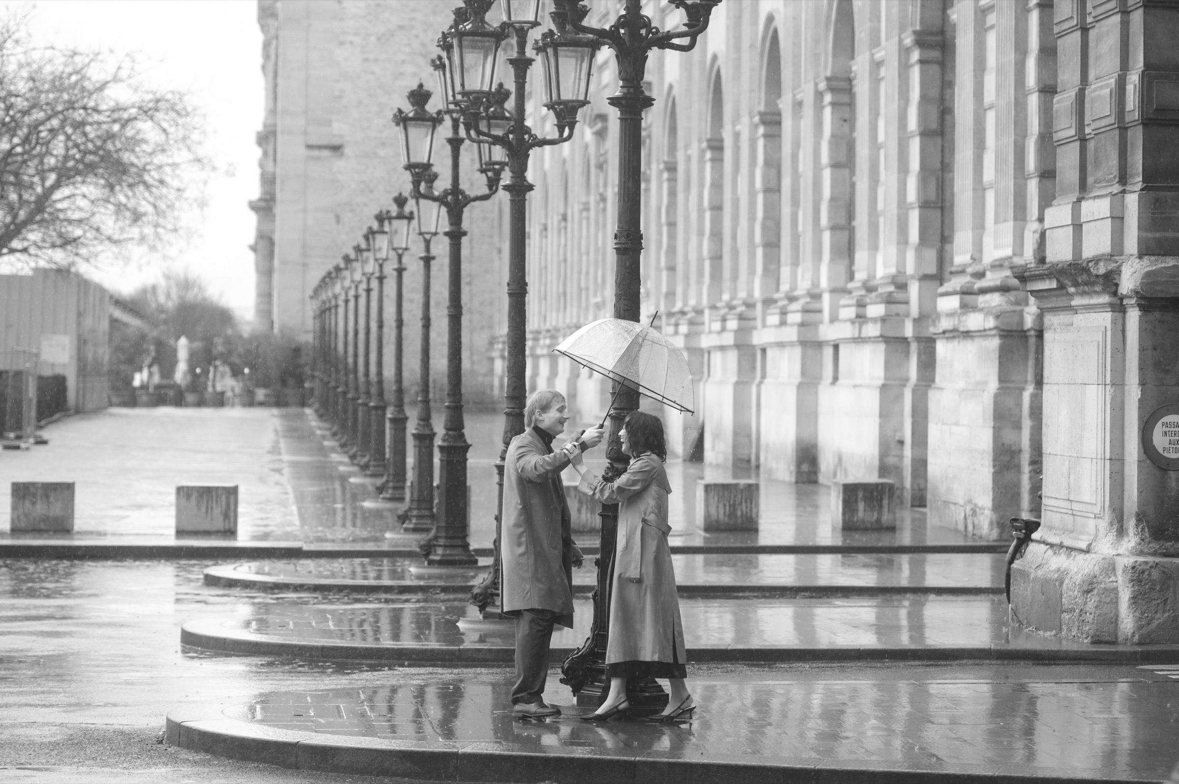 A newly engaged couple beneath an umbrella in Paris