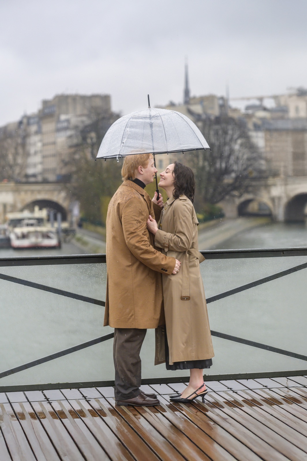 A couple beneath an umbrella overlooking the Seine