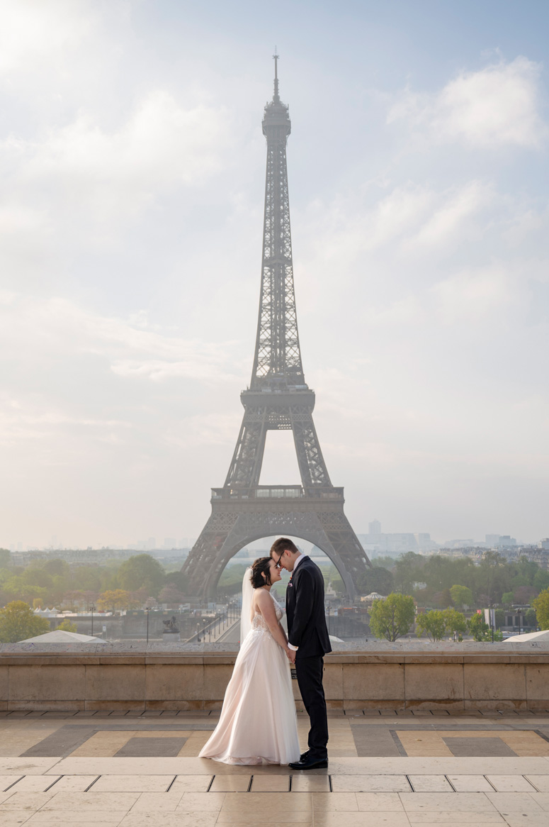 A couple photographed in front of the Eiffel Tower in Paris